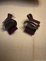 front view of both earrings showing purple panels, silver-tone wrap and black striped enamel