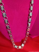 Full view of necklace showing round embossed disc links