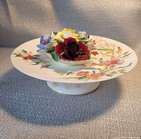 Side view of cake stand with Radnor floral posy on top