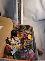 Boxed pair of spiral candles beside box of assorted small items