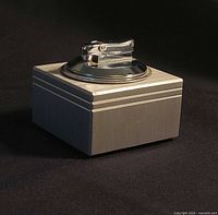 Oblique view of brushed aluminum block lighter showing chrome top and incised grooves