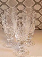 Front angle view of five cut glass stemware showing pattern and stems