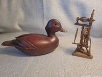Wood duck and miniature spinning wheel full view