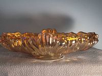 Side view of the elongated marigold carnival glass bowl