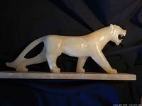 Side view of marble cat sculpture showing form and base