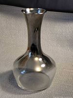 Front view of mirrored glass vase showing reflective neck and clear base