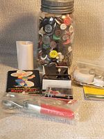 Overview of jar filled with buttons and other sewing items
