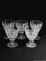 Five matching Stuart crystal footed goblet glasses grouped together