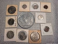 Group shot of nine U.S. coins in holders surrounding large novelty Buffalo nickel