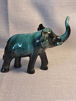 Left side profile of green drip glaze ceramic elephant figurine