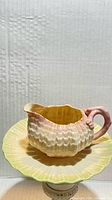 Side view of Belleek creamer on saucer