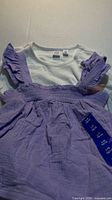 Both tops laid out, showing lavender smocked top over white ribbed top with tags