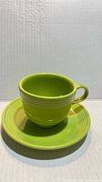 Chartreuse Fiesta teacup on matching saucer, front view