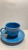Turquoise Fiesta cup on saucer, frontal view