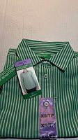 Folded green and white striped dress shirt with attached size and brand tags
