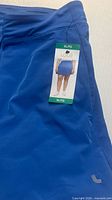 Front view of blue Lolë skort with tag attached