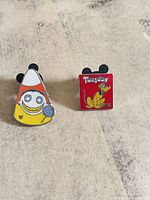 Both Disney pins side by side on surface