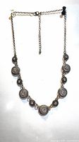 Full view of silvertone necklace showing round crystal medallions and extender chain