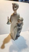 Front view of Lladro porcelain figurine, boy with candle and child
