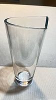 Front view of clear glass vase showing asymmetrical triangular rim and tapered body