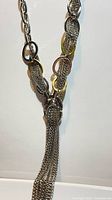 Close view of necklace showing tassel and mixed metal oval links