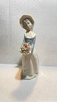 Front view of porcelain lady figurine with basket of roses