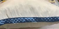 Side profile of pillow showing blue quilted gusset