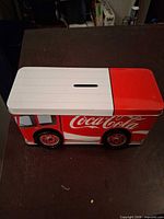 Coca-Cola delivery truck tin bank showing coin slot and graphics