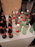Group of mixed Coca-Cola bottles, sealed and empty