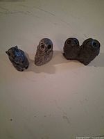 Three figurines—squirrel, single owl, double owl—displayed side by side