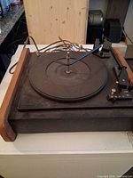 Overhead view of complete turntable showing wood trim, platter, tonearm and attached cords