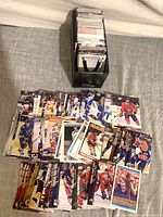 Overhead view showing spread of hockey trading cards and storage box with cards inside