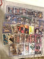 Overview of all sleeved basketball cards spread out showing various Panini Prizm, Select, Donruss Optic, Hoops designs