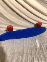 Top view of blue plastic deck with red wheels attached