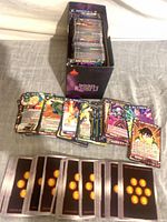 Storage box containing stacks of Dragon Ball Super cards with additional loose cards displayed