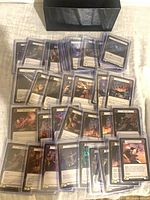 Group of Flesh and Blood cards in top loaders with black storage box