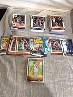 Stacks and spread of NBA Hoops and Topps Chrome basketball cards laid on surface