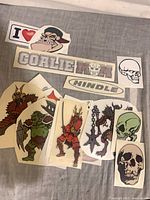 Lot overview showing multiple vinyl stickers including warriors, skulls, logos