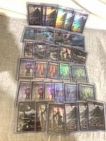 All 52 foil full-art basic lands arranged in rows inside toploaders