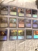 Front view of fifteen sleeved foil rare cards in toploaders