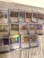 Group shot of several foil Magic cards in toploaders