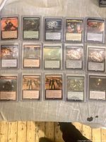 Fifteen of the sleeved cards laid out in three columns, front view