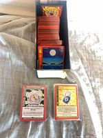 Stack of MetaZoo cards inside storage box with two sleeved cards displayed in front