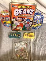 Overall lot showing tin, two blister packs, two trays, bag of loose Beanz