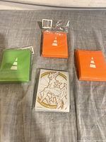 Four sleeve packs laid out: green, two orange, white Arceus design