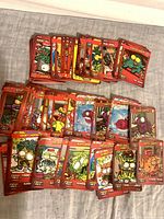 Stack and spread of red-border Trash Pack cards on table