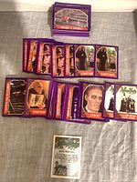 Stack and spread of purple-border Addams Family trading cards