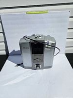 Front view of AlkaViva Athena H2 water ionizer showing LCD, buttons, rotary knob and attached hose