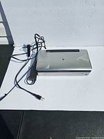 Top view of HP Officejet 100 printer with power adapter and cord