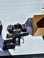 All cameras arranged together with empty cardboard box